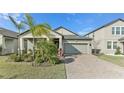 Lovely single-Gathering home with a well-maintained lawn and brick-paved driveway at 13218 Satin Lily Dr, Riverview, FL 33579