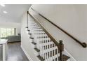 Staircase with white painted spindles and wooden handrail, with view into the living room at 12326 Terracina Chase Ct, Tampa, FL 33625