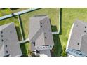 Aerial view of a gray roofed home with a fenced backyard surrounded by lush green lawns at 13106 Zolo Springs Cir, Riverview, FL 33579