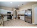 Bright kitchen featuring white cabinets, stainless steel appliances, granite countertops and tile floors at 5913 Lawrin Ct, Wesley Chapel, FL 33544