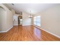 Open living room showcasing hardwood floors, neutral paint, and natural light from large window at 5913 Lawrin Ct, Wesley Chapel, FL 33544