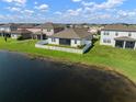 Aerial view of a home on a lake showing a manicured lawn and white picket fence at 11717 Navajo Sandstone St, Riverview, FL 33579