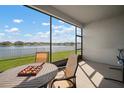 Relaxing screened patio with table and chairs overlooking the serene lake view and lush green lawn at 11717 Navajo Sandstone St, Riverview, FL 33579