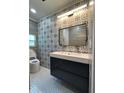 Modern bathroom featuring a sleek vanity, stylish mirror and decorative tiling at 2301 46Th S St, St Petersburg, FL 33711