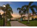 Charming home with a well-manicured lawn, beautiful palm trees, and a paved driveway leading to a bright blue front door at 3943 Fontainebleau Dr, Tampa, FL 33634