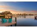 Waterfront home with a private dock furnished with Adirondack chairs, offering scenic views of the tranquil waters at 3943 Fontainebleau Dr, Tampa, FL 33634