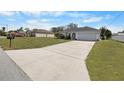 Charming single-story home with a well-manicured lawn and a long concrete driveway leading to an attached garage at 4306 Goldcoast Ave, Spring Hill, FL 34609