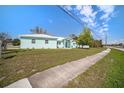 Single story light-green home with a metal roof and generous front yard, as viewed from the street at 9321 Regatta Cir, Spring Hill, FL 34606