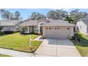 Well-maintained single-story home with a tidy lawn and a convenient two-car garage at 11018 Courtland St, Trinity, FL 34655