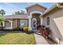Close-up of the front entrance of the home highlighting the manicured landscaping at 11018 Courtland St, Trinity, FL 34655
