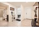 Bright hallway leads to a bathroom and bedroom; features neutral tile floors, white walls, and a view of the front door at 1274 Ocean Spray Dr, Ruskin, FL 33570