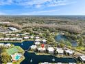 Aerial view of community featuring lake, pool, tennis courts, and beautiful landscaping at 15238 E Pond Woods Dr, Tampa, FL 33618