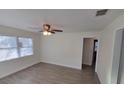 Open-concept living room featuring a ceiling fan, wood-look floors, and neutral paint at 2432 Auburn S St, St Petersburg, FL 33712