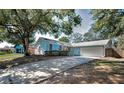 Charming light blue single-story home featuring a two-car garage and well-maintained landscaping at 2580 Redwood Way, Clearwater, FL 33761