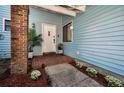 Inviting entryway with a light blue exterior, brick accents, and well-manicured landscaping at 2580 Redwood Way, Clearwater, FL 33761