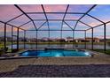 Screened pool with brick patio offers serene water views and adds luxury to outdoor living at 32773 Tree Of Life Ave, Wesley Chapel, FL 33543