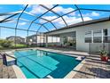 Inviting pool with a screened enclosure and brick pavers with a view of the home at 32773 Tree Of Life Ave, Wesley Chapel, FL 33543