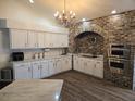 Spacious kitchen featuring white cabinets, brick backsplash, and stainless steel appliances at 6601 Thackston Dr, Riverview, FL 33578