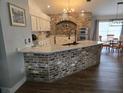 Modern kitchen with marble countertops, brick-accented island, and updated fixtures at 6601 Thackston Dr, Riverview, FL 33578