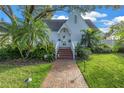 Attractive home exterior with manicured lawn, mature palm trees, and brick walkway at 156 21St Ne Ave, St Petersburg, FL 33704