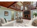 Cozy living room features a brick fireplace, wood ceilings, and an open loft area at 2901 Pelham Rd N, St Petersburg, FL 33710