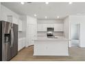 Modern kitchen featuring stainless steel appliances, white cabinetry, and a center island with a quartz countertop at 3980 Big Sky Dr, Spring Hill, FL 34604