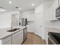 Bright kitchen with white cabinets, stainless steel appliances, and a spacious island for food preparation and dining at 3980 Big Sky Dr, Spring Hill, FL 34604