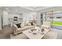Open-concept living room featuring a modern kitchen, dining area, and large sliding doors to the backyard at 3980 Big Sky Dr, Spring Hill, FL 34604