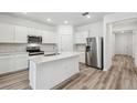 Modern kitchen with stainless steel appliances, white cabinets, and a kitchen island with quartz countertops at 4219 Big Sky Dr, Spring Hill, FL 34604
