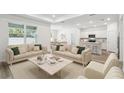 Bright and airy living room featuring two sofas, large windows, and an open floor plan leading to the kitchen at 4219 Big Sky Dr, Spring Hill, FL 34604
