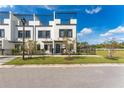 Modern townhome exterior with trellises on the roof, black trim, a black metal fence and green grass at 6207 64Th N Way, Pinellas Park, FL 33781
