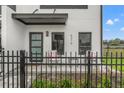 A close-up of a modern townhome with a covered patio area with black metal fence and chairs at 6207 64Th N Way, Pinellas Park, FL 33781