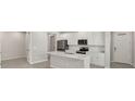 Bright kitchen featuring white cabinets, stainless steel appliances, and a modern island with a sink at 6224 Timberdale Ave, Wesley Chapel, FL 33545