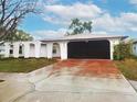 Charming single-Gathering home with a freshly painted exterior and a red stained driveway leading to the garage at 6718 Ranchwood Loop, New Port Richey, FL 34653
