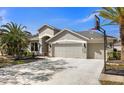 Stylish single-Gathering home with a three-car garage, stone accents, and a basketball hoop for recreational fun at 8208 Pinewood Run Ct, Tampa, FL 33647