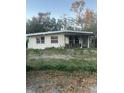 Home exterior needing TLC, featuring a covered front porch and barred windows for enhanced security at 926 E 120Th Ave, Tampa, FL 33612