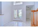Spacious tiled foyer with decorative double doors and view of the staircase and entry to other rooms at 18126 Kara Ct, Tampa, FL 33647