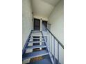 Exterior staircase leading to upper-level condo units in a multi-Gathering building with metal banisters and outdoor access at 256 Cypress Ln # 120, Oldsmar, FL 34677