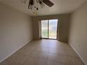 Bedroom with neutral walls, ceiling fan and sliding glass door leading to outdoor space at 3223 Coats Rd, Zephyrhills, FL 33541