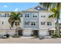 Daytime view of townhome exterior featuring manicured landscaping, private garages, and inviting facade at 3226 Nautical S Pl, St Petersburg, FL 33712