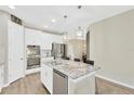Modern kitchen with stainless steel appliances, a large kitchen island with a marble countertop, and white cabinetry at 4071 Balcony Breeze Dr, Land O Lakes, FL 34638
