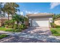 Beautiful home showcasing a two-car garage, paver driveway, and manicured landscaping at 4946 Sapphire Sound Dr, Wimauma, FL 33598