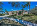 A well-maintained home with a manicured lawn, palm trees, and beautiful curb appeal at 9101 Highland Ridge Way, Tampa, FL 33647