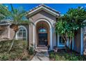Inviting front door with an arched entryway and beautiful landscaping at 9101 Highland Ridge Way, Tampa, FL 33647