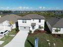 This aerial view showcases a two-story home with a well-kept yard, close to a scenic lake at 11022 Moonsail Dr, Parrish, FL 34219