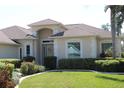 A well-maintained, light beige home with a green lawn and mature landscaping evokes feelings of warmth at 6618 Peach Tree Creek Rd, Bradenton, FL 34203