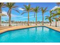 Sparkling in-ground pool with poolside deck and lush palm trees, perfect for relaxation at 7984 1St S Ave, St Petersburg, FL 33707