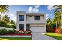 Modern two-story home featuring a neutral palette, dark windows, and vibrant landscaping at 902 W Fribley St, Tampa, FL 33603