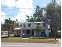 Charming two-story home featuring a welcoming front porch, mature trees, and classic architectural details at 1001 W Baker St, Plant City, FL 33563