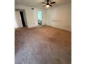 Bedroom with neutral carpet flooring and a ceiling fan, leading to ensuite bathroom at 106 Lakeside Ct, Oldsmar, FL 34677